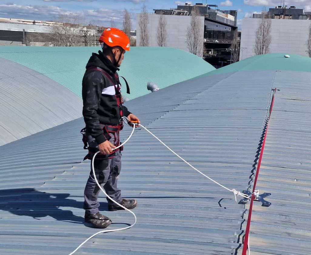 hombre sobre cubierta de nave industrial casco rojo